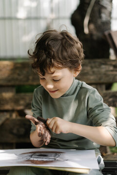 Curious child creating imaginative drawings outdoors