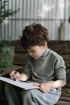 Creative little boy exploring art outside alone
