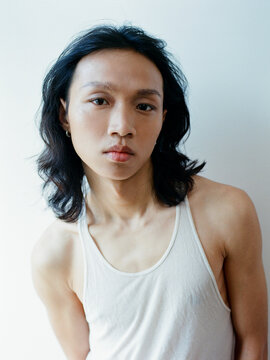 Young Person Wearing White Tank Top Looking at Camera
