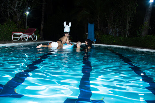 Group of Friends Enjoying Time in a Pool at Night