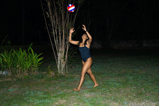 Playing Volleyball at Night in the Backyard With Friends