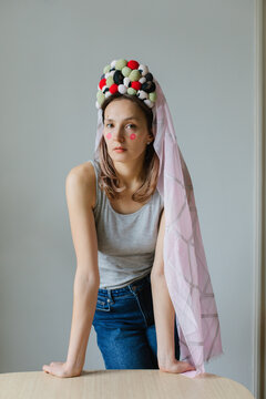 A woman in a grey sweater with a crown