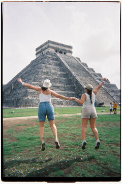 Friends jumping with joy at Chichen Itza pyramid