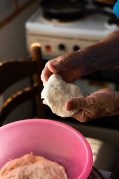 Elderly Woman Stretching Homemade Dough by Hand