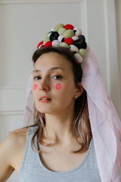 A woman in a grey sweater with a crown