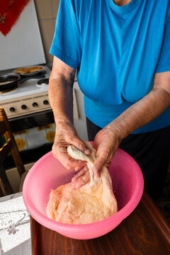 Elderly Woman Stretching Homemade Dough by Hand