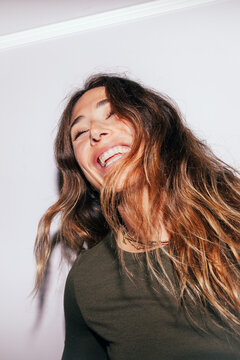 Joyful young woman laughing in studio portrait