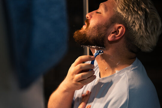 Man Shaving Neck Beard Line In Bathroom Mirror