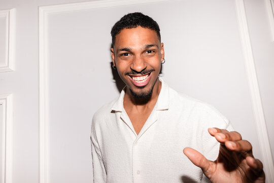 Smiling young man in white shirt posing indoors