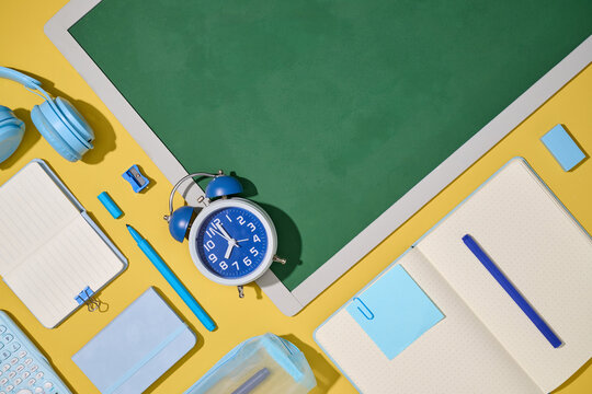 Back to school supplies arranged neatly on a yellow background