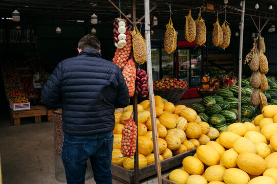 Exploring Vibrant Fruits at a Lively Market in Autumn Light