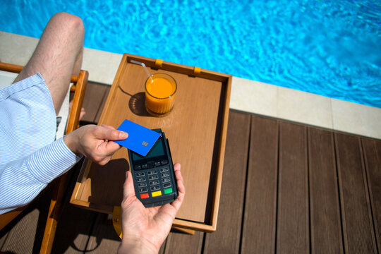 Anonymous man's hand paying with a  credit card via a pos terminal.