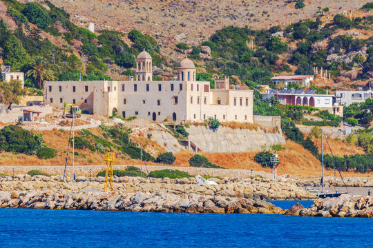 Beautiful view of historic monastery on rocky Mediterranean coast with hills and sea. Crete. Greece.