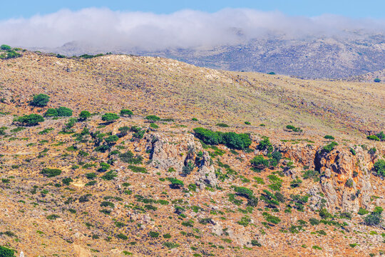 Beautiful view of rocky mountain hills with sparse vegetation and low clouds. Crete. Greece.