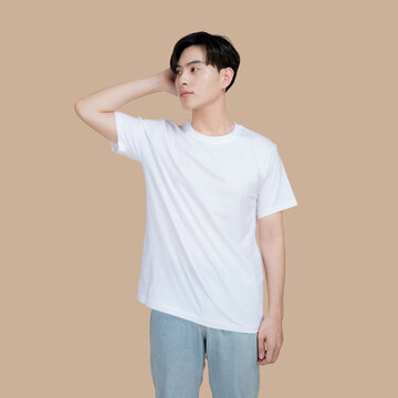 Young man in a white t-shirt and jeans posing against a neutral background