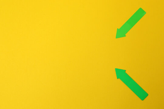 Paper arrow on color background, top view