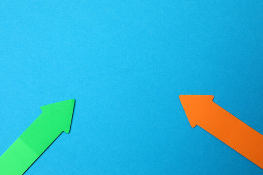 Paper arrow on color background, top view