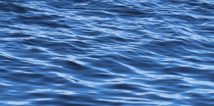 Soft waves on light blue water surface, natural background