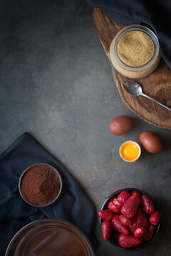 Overhead view of assorted Ingredients for making a chocolate strawberry cake