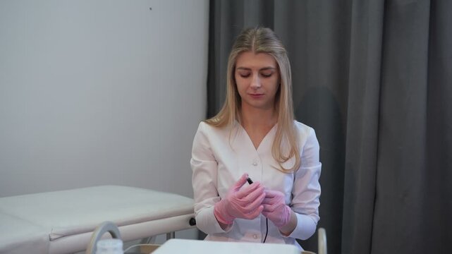 Professional permanent makeup artist preparing tattoo machine