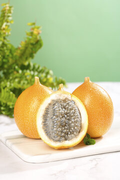 Golden Passion Fruit from Yunnan China Cut Open Showing Sweet Delicious Pulp and Seeds on White Board