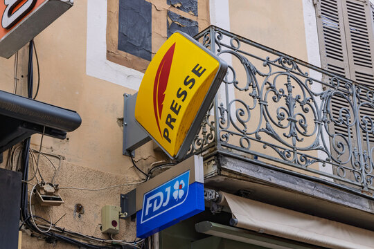 Bourg-en-Bresse, France - July 26, 2026: Yellow Presse newsagent shop sign and FDJ lottery sign hanging on a balcony in Bourg-en-Bresse.
