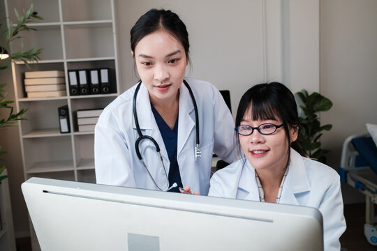 Doctors collaborating looking at computer screen in clinic