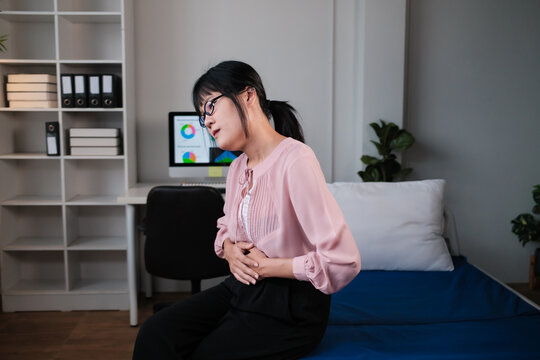 Woman experiencing abdominal pain holding her stomach