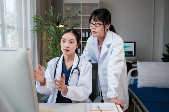 Two female doctors discussing patient data on computer