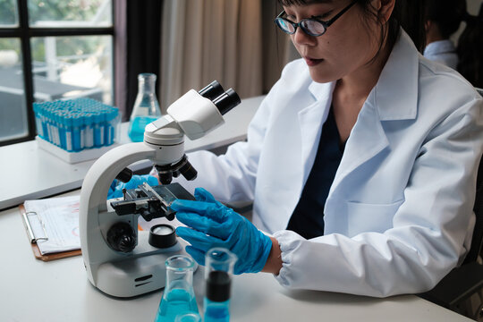 Female scientist researching using microscope in laboratory
