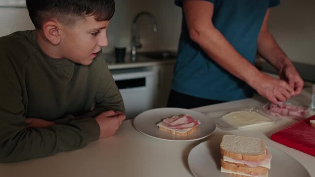 Father And Son Making Sandwiches Together In Kitchen