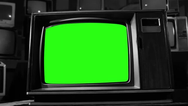 Retro television with a vibrant green screen, surrounded by vintage tv sets in a monochromatic setting, offering ample copy space.