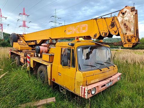 Trutnov, Czech Republic - August 5 2026 A yellow CKD Tatra 815 crane truck is parked in a grassy field in the Czech Republic. 