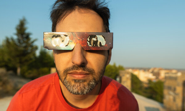 Man observing a solar eclipse using protective glasses