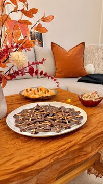 Herbstlich dekorierter Esstisch mit K&uuml;rbis Blumenstrau&szlig; Snacks und gem&uuml;tlicher Herbstdeko