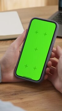 Woman sit use digital tech cell phone open green screen mock up. Hand scroll phone web site swipe unlock. Girl hold mobile closeup. Turn on chroma key page Cozy home background. Online app copy space