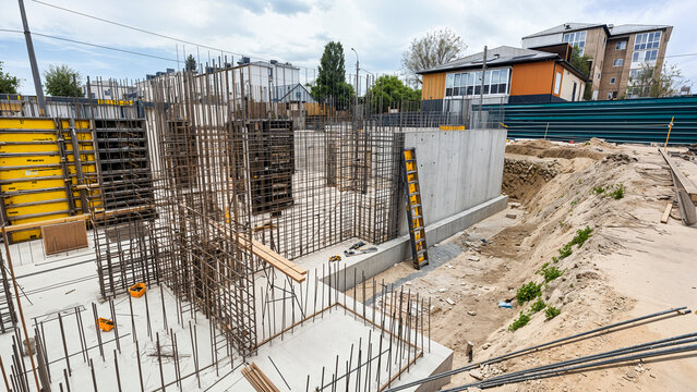 Construction site showing building foundation with concrete and rebar framework.