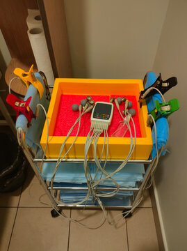 Electrocardiogram ECG machine with multiple electrodes and cables on a medical trolley in a clinic, modern cardiac diagnostic equipment, healthcare technology, hospital examination setup,