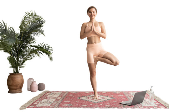 Young woman performing tree yoga pose with prayer hands during an online class