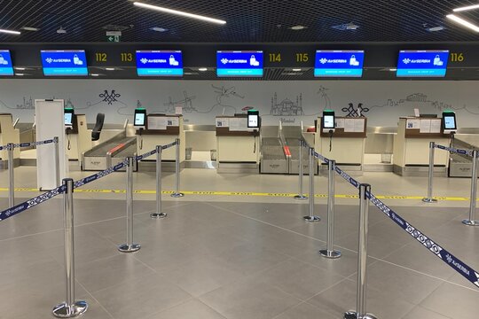 Belgrade, Serbia &ndash; June 25, 2026: Modern Air Serbia baggage drop off counters with digital screens and rope barriers in empty terminal of Nikola Tesla Airport.