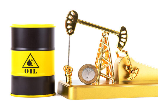 1 riyal coin of the Kingdom of Saudi Arabia and a model of a gold oil pump