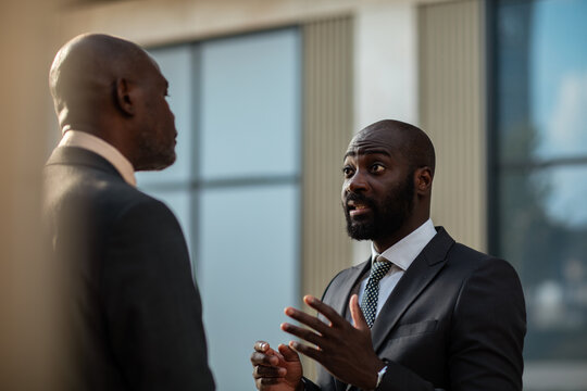 Two businessmen discussing outside office building