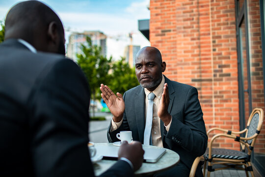 Two businessmen negotiating at an outdoor cafe