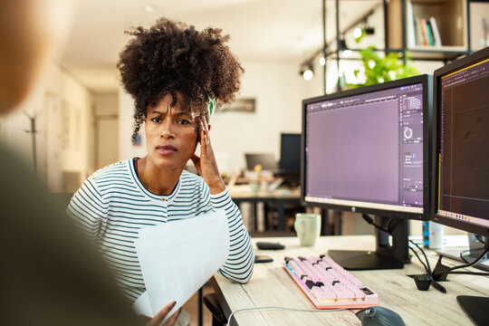 Concerned designer discussing project feedback in modern office
