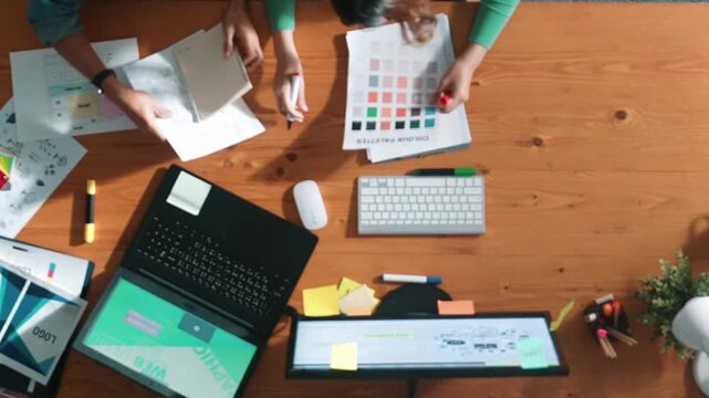 Top down view of smart businessman hand choosing color palettes while designing logo graphic. Aerial view of smart interior designer design and select color theme by using color palettes. Symposium.