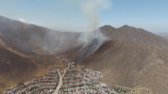 Drone Aerial View of Wildfire Burning Hillside with Heavy Smoke