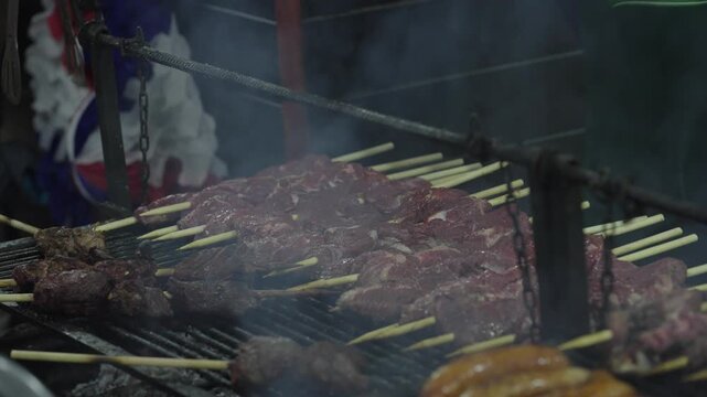 Grilled Meat Skewers and Sausages Cooking on Outdoor Barbecue Grill
