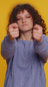 Angry aggressive young woman showing fig negative gesture, you dont get it anyway. Rapacious, avaricious, acquisitive. Body language. Refusal fig sign. Greedy avaricious girl on yellow background