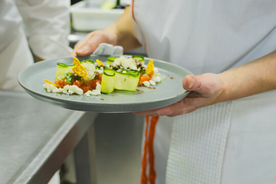 Professional chef presenting a creative and healthy gourmet dish, preparing exquisite international cuisine with innovation and sustainability for a unique gastronomic experience