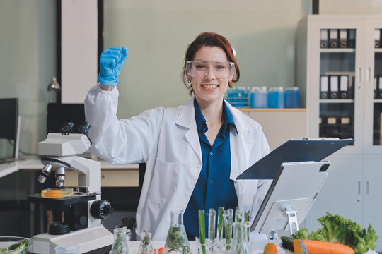 Scientists in lab coats work with plants in a modern lab, focusing on research and experimentation under bright, sterile conditions.